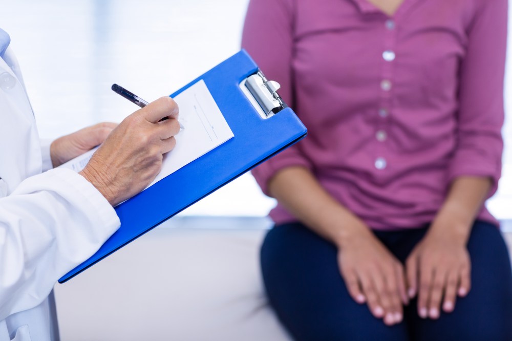 Doctor writing on clipboard in clinic