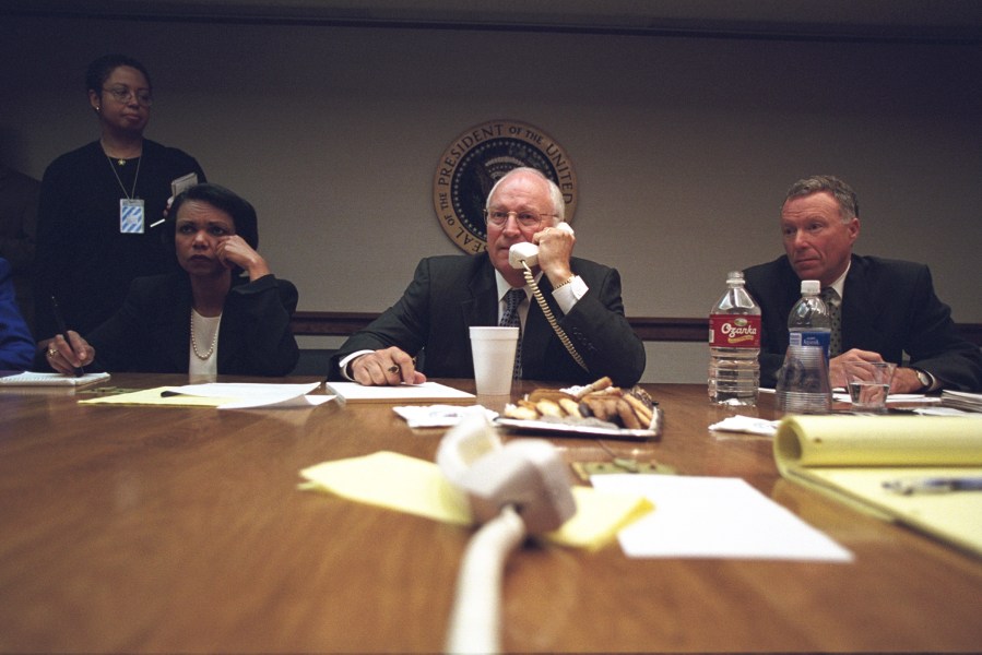 Cheney talks on the phone as Rice and Lewis 