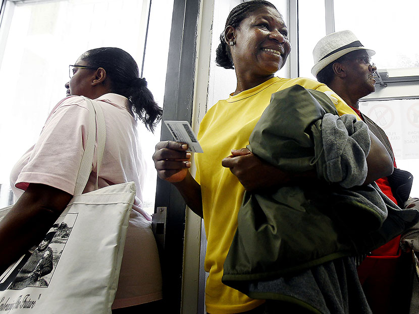 Chantell Wallace (middle) holds out her ID while waiting in line with fellow Shelby County residents during the first day of early voting, October 17, 2012 in Memphis, TN (Photo by Mark Weber/The Commercial Appeal/ZUMAPRESS.com)