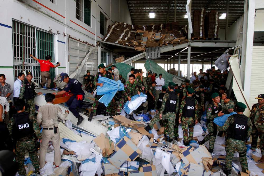 Rescue workers and soldiers search through a site of the accident in a shoe factory in the Kong Pisei district of Kampong Speu province, 50 km (30 miles) west of the capital, Phnom Penh May 16, 2013. Three people were killed when the ceiling of a...