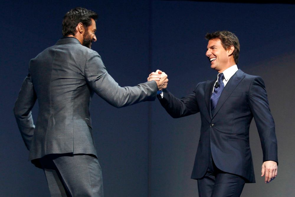 Actor Hugh Jackman (L) welcomes actor Tom Cruise to the stage as Jackman hosts the annual shareholders meeting for Walmart in Fayetteville, Arkansas June 7, 2013. (REUTERS/Rick Wilking)