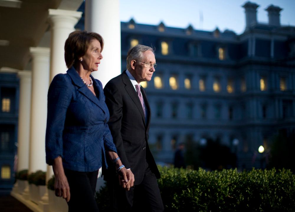 U.S. House Minority Leader Nancy Pelosi (D-CA) (L) and Senate Majority Leader Harry Reid (D-NV) walk from the West Wing of the White House in October 2, 2013, following a meeting with U.S. President Barack Obama.
