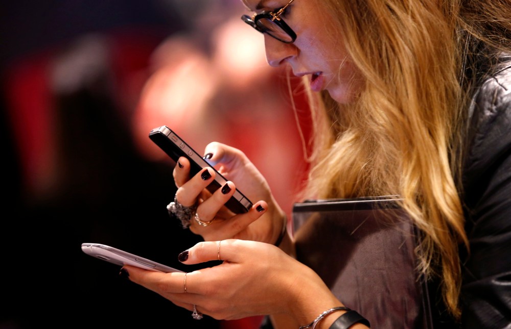 A woman uses a smartphone in New York City, in this picture taken November 6, 2013.