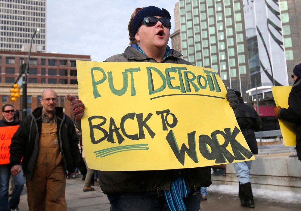 Jennifer Teed joins a group of labor activists as they rally for jobs outside Cobo Center ahead of the media preview of the North American International Auto Show in Detroit, Michigan January 12, 2014.