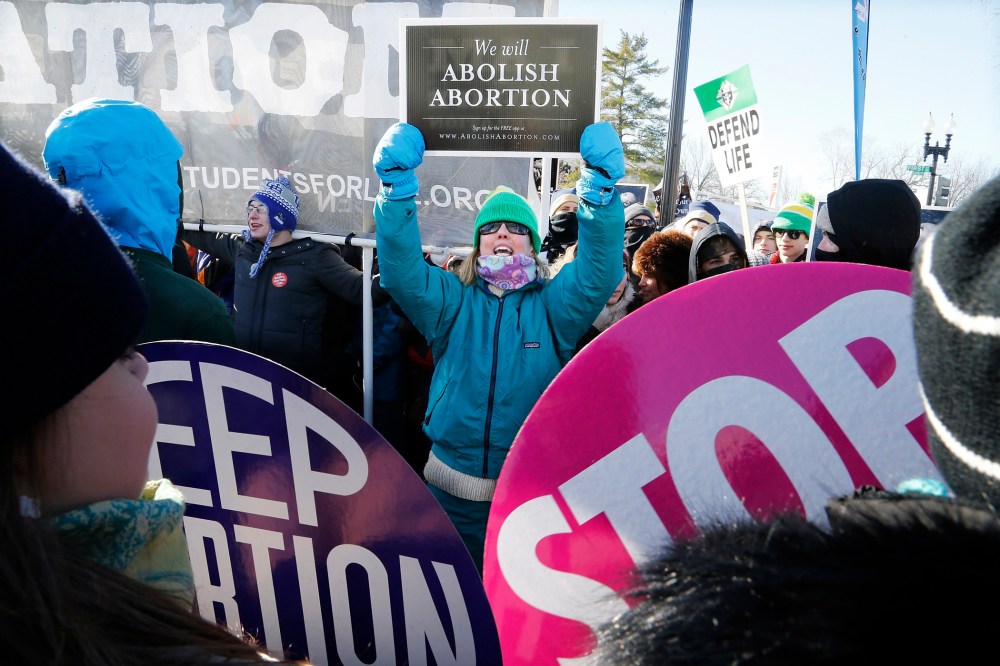 An anti-abortion demonstrator (C) shouts at pro-choice demonstrators in front of the U.S. Supreme Court during the annual March for Life in Washington, January 22, 2014.
