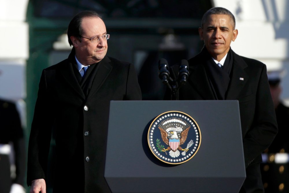 French President Francois Hollande (L) looks over at U.S. President Barack Obama during a State Arrival ceremony in Hollande's honor on the South Lawn of the White House in Washington, February 11, 2014.