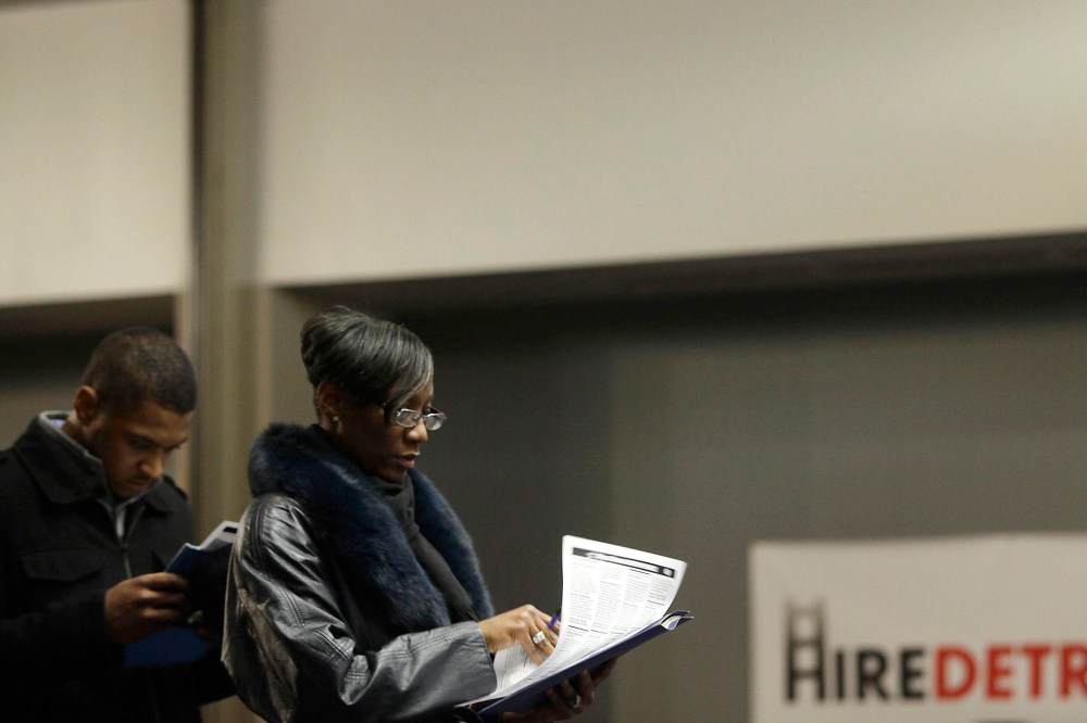 A man and a woman attending a job fair wait in line in Detroit, Mich. on March 1, 2014.
