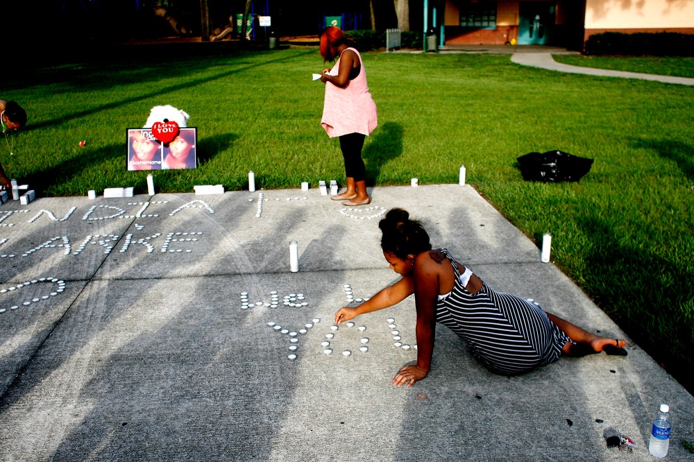 Lashell Bell, 18, right, of Tampa places candles spelling out ''We Love You'' during a vigil on July 22, 2015 in Florida, in memory of India Clarke. (Photo by Octavio Jones/Tampa Bay Times/Zuma)