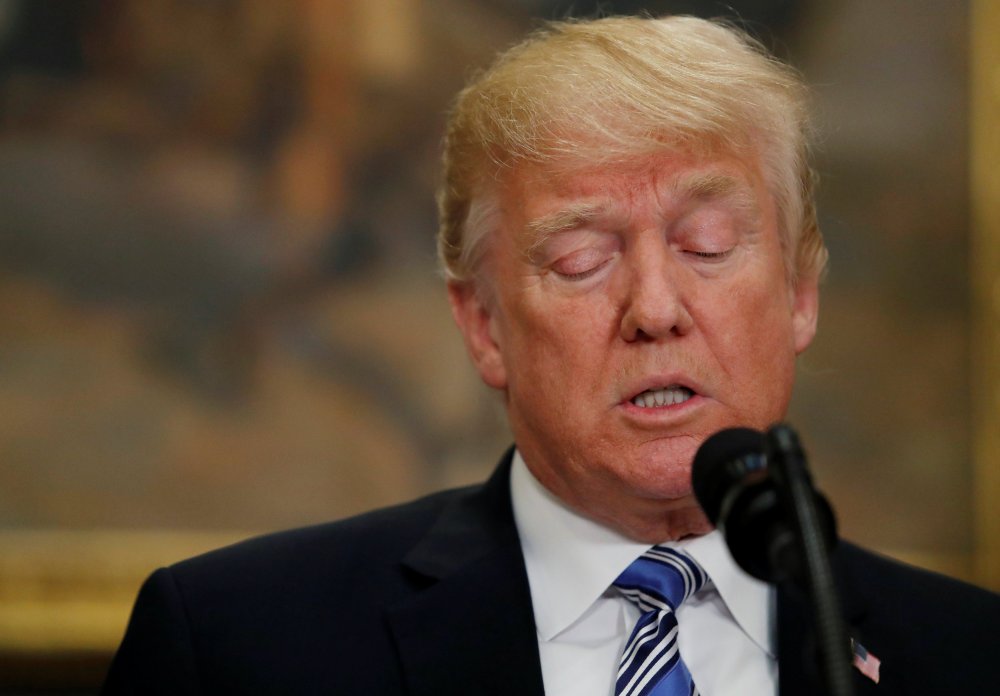 Image: U.S. President Donald Trump signs a presidential proclamation placing tariffs on steel and aluminum imports while surrounded by workers from the steel and aluminum industries at the White House in Washington