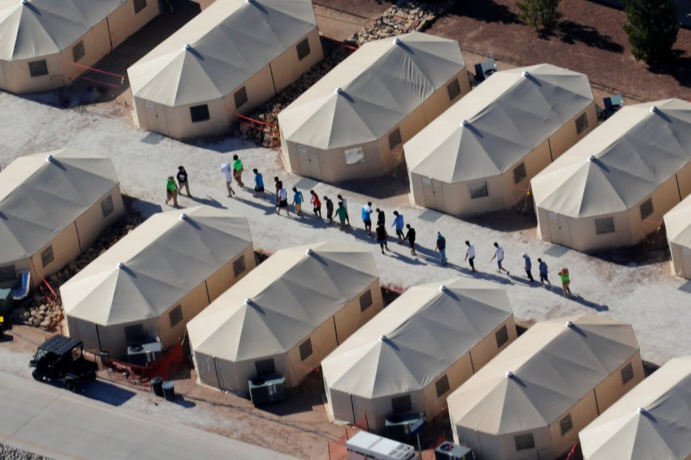 Image: Immigrant children now housed in a tent encampment under the new "zero tolerance" policy by the Trump administration are shown walking in single file at the facility near the Mexican border in Tornillo, Texas