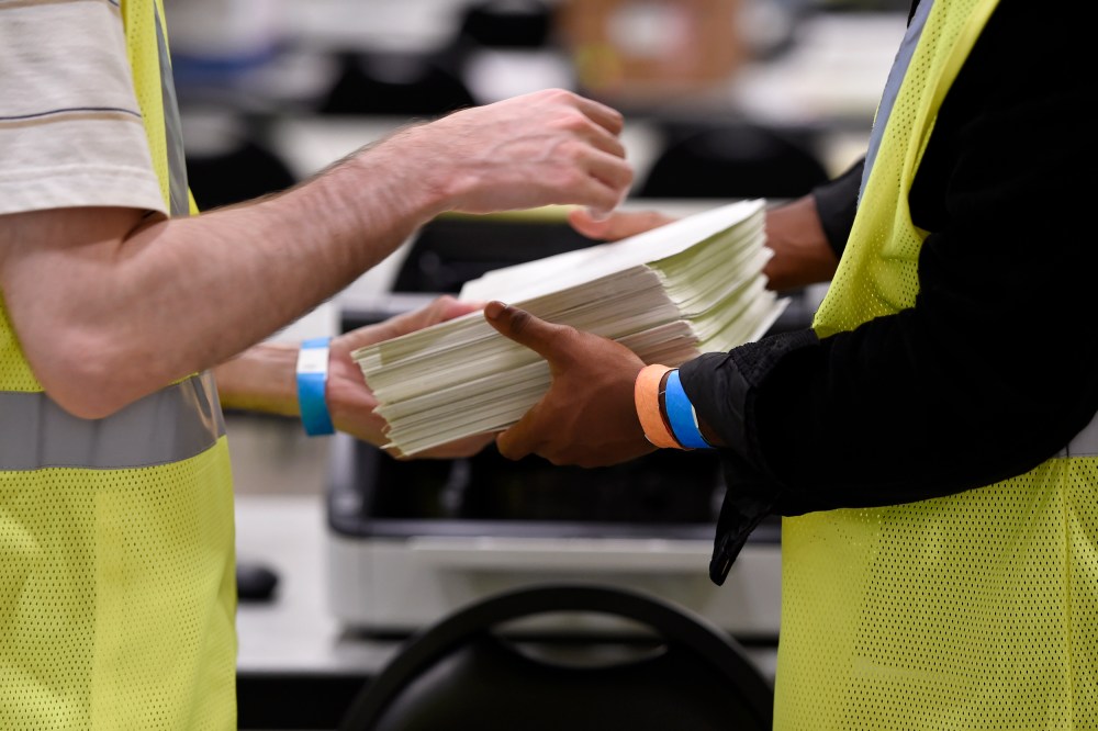 Cobb County Election officials handle ballots during a machine recount on Nov. 24, 2020, in Marietta, Ga.