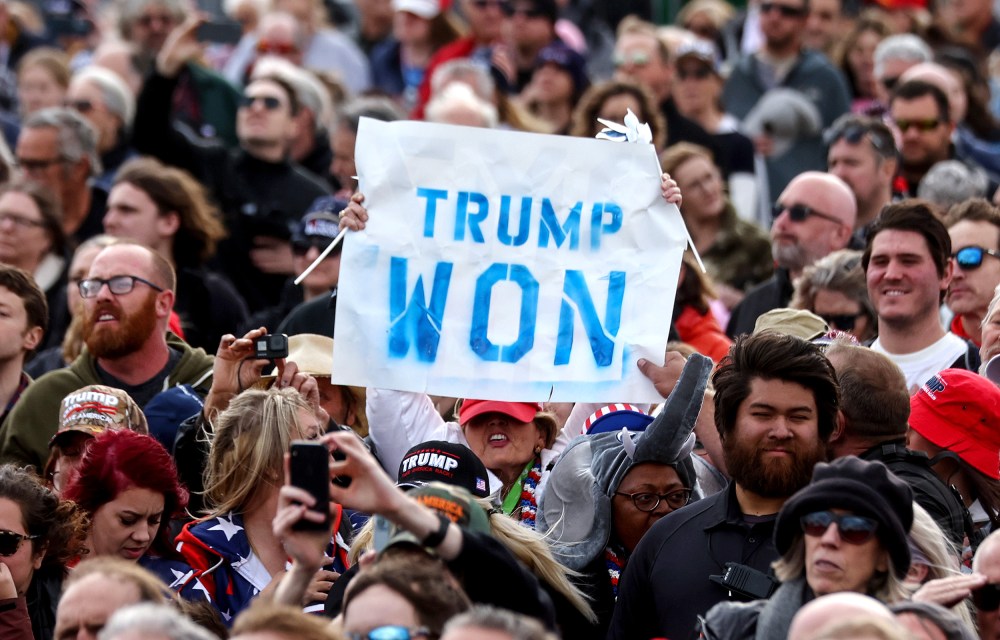 Image: A person in the crowd holding a sign that reads,"Trump Won".