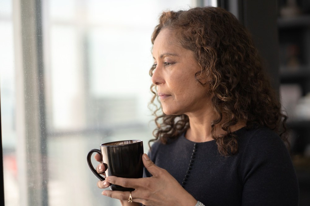 Portrait of a beautiful black woman drinking tea by window