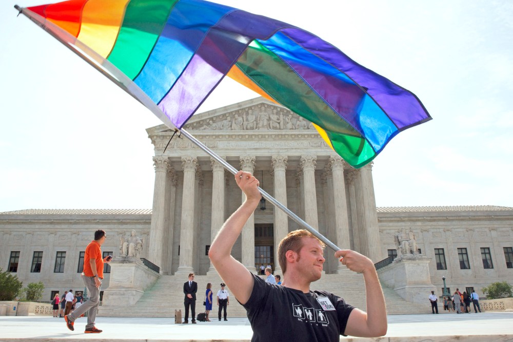 A person waves a rainbow flag in support of gay marriage outside of the Supreme Court