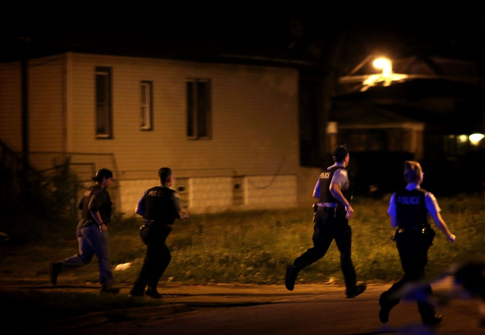 Chicago police respond to gunfire while searching for a gunman after finding three gunshot victims in the early hours of July 7, 2014, in Chicago.