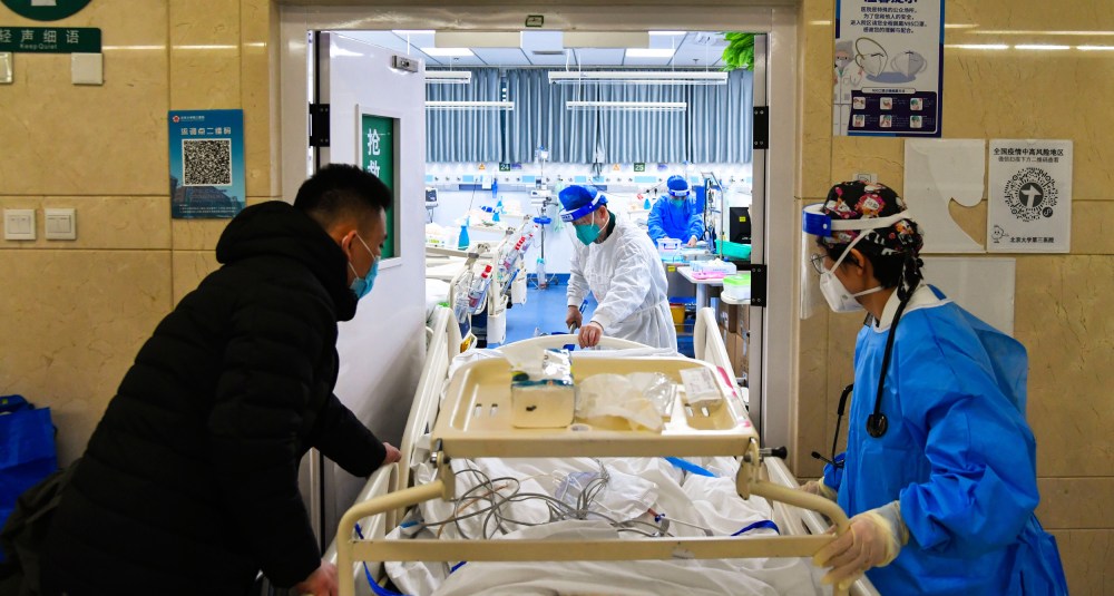 Image: Medical workers move a patient into emergency care unit at Peking University Third Hospital in Beijing.