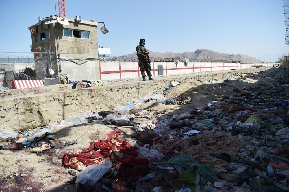 TOPSHOT - A Taliban fighter stands guard at the site of the August 26 twin suicide bombs, which killed scores of people including 13 US troops, at Kabul airport on August 27, 2021.