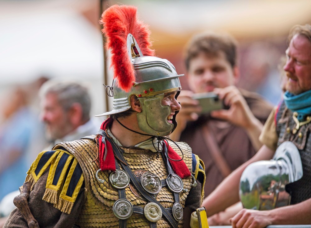 A performer in the Roman centurion costume talks to spectators