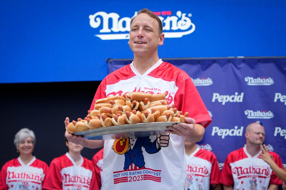 Competitive eater Joey Chestnut holds a plate of hotdogs representing his world record for eating 76 hotdogs and buns in ten minutes during a weigh-in ceremony before the Nathan's Famous July Fourth hot dog eating contest on July 3, 2023, in New York.