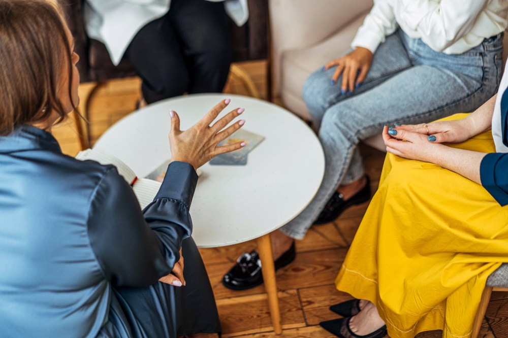 Four women in armchairs and talking.