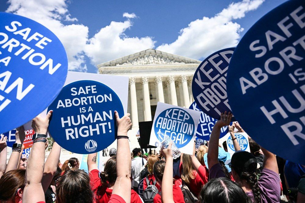 People hold signs saying "Safe Abortion is a Human Right" and "Keep abortion legal"