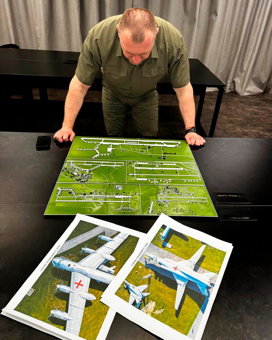 head of the Security Service Vasyl Malyuk studies a photo of a map of Russia's strategic aviation location