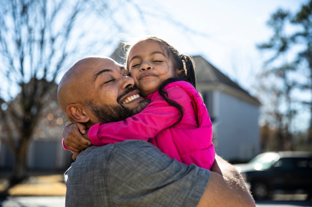 Father holding young daughter outdoors