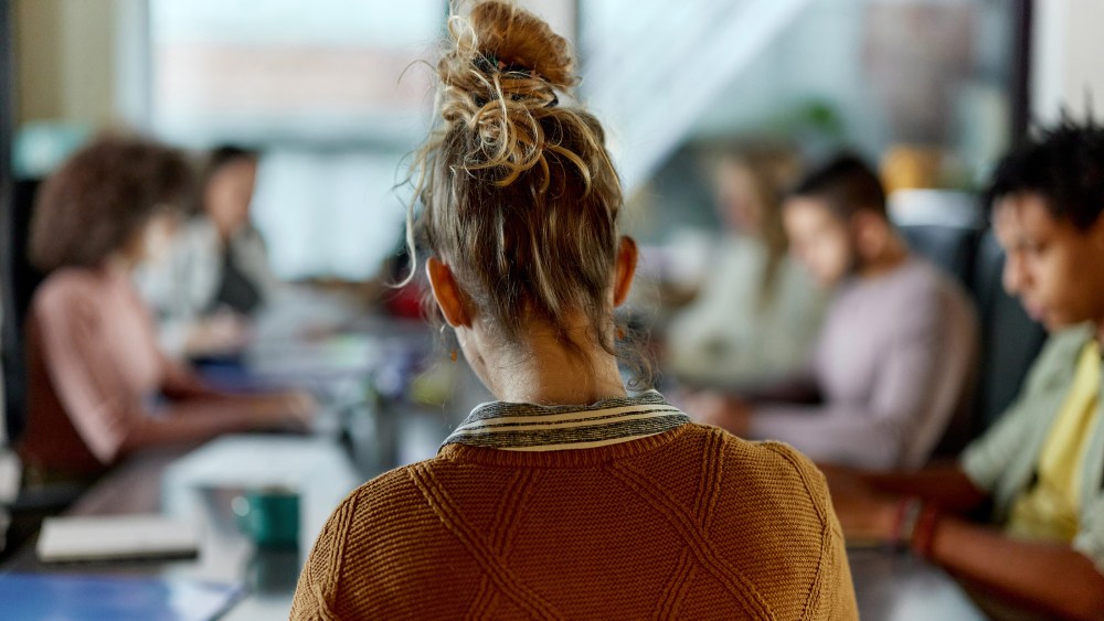 Back view of creative woman on a meeting in the office.