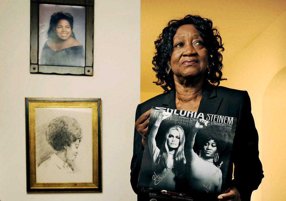 Dorothy Pitman Hughes poses in her St. Johns, Fla. home on Sept. 24, 2013, holding a poster using a 1970's image of herself and Gloria Steinem.