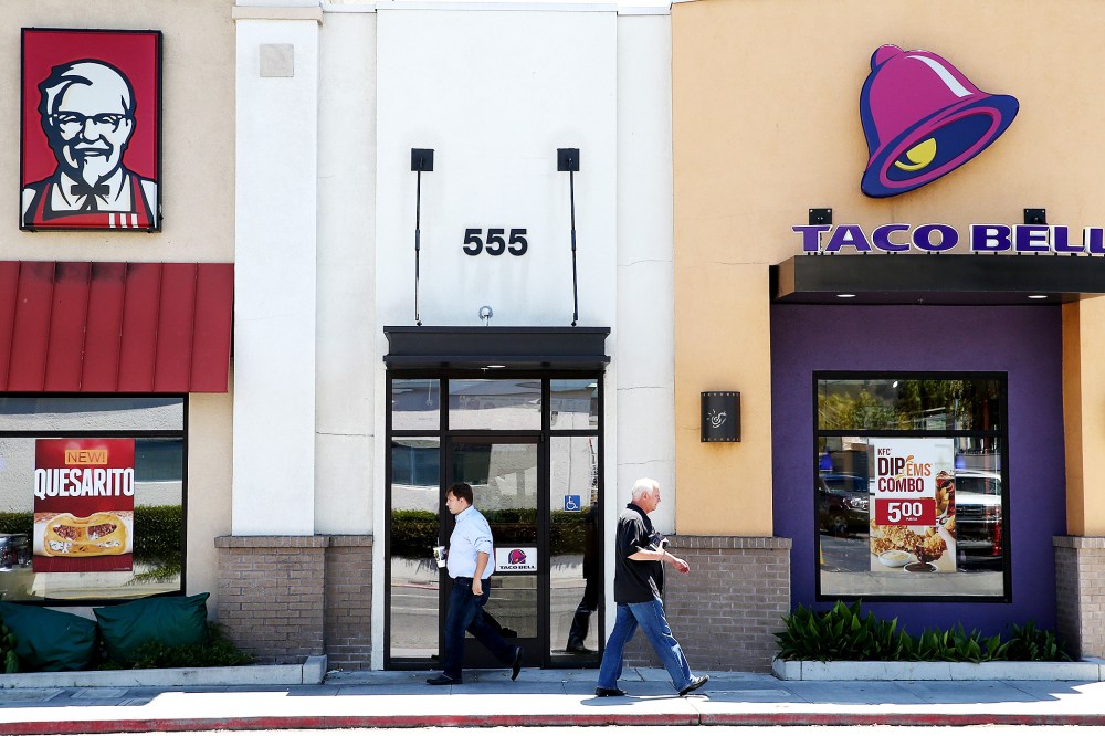 Pedestrians walk by a KFC and a Taco Bell restaurant on July 2, 2014 in San Rafael, California.