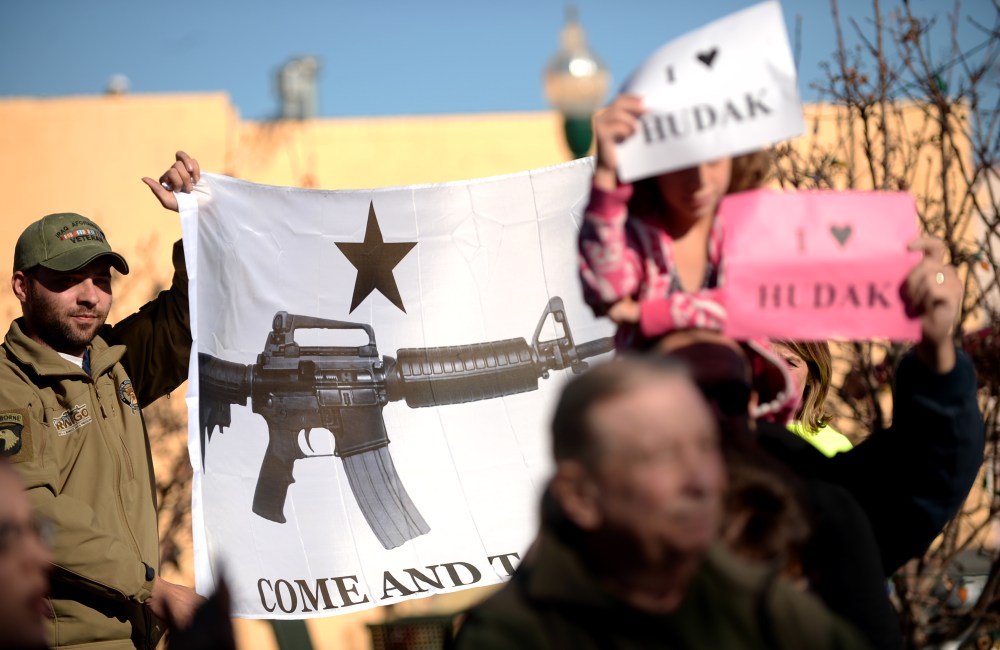 Protesters hold the  banner by supporters and friends who hold press conference for Democratic state Sen. Evie Hudak at the Arvada Library. Arvada, Colo. on Nov. 27, 2013.