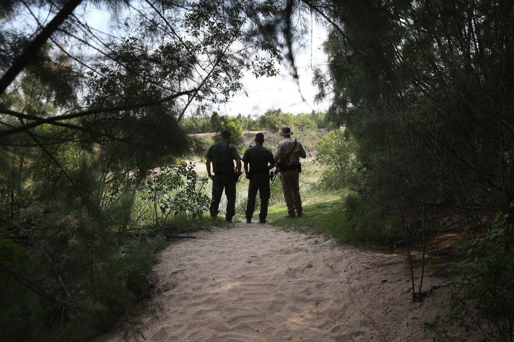 Law enforcement agents watch for immigrants crossing the Rio Grande illegally into the United States on July 24, 2014 in Mission, Texas. (Photo by John Moore/Getty)