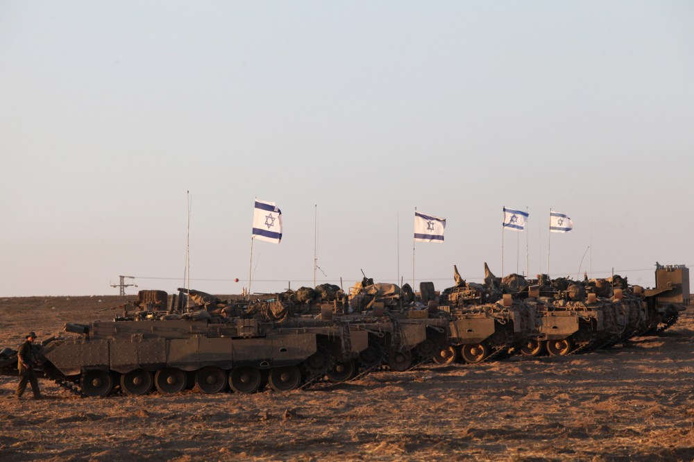 Israeli army's armoured personnel carriers (APC) are positioned along the border between Israel and the Hamas-controlled Gaza Strip on July 26, 2014.
