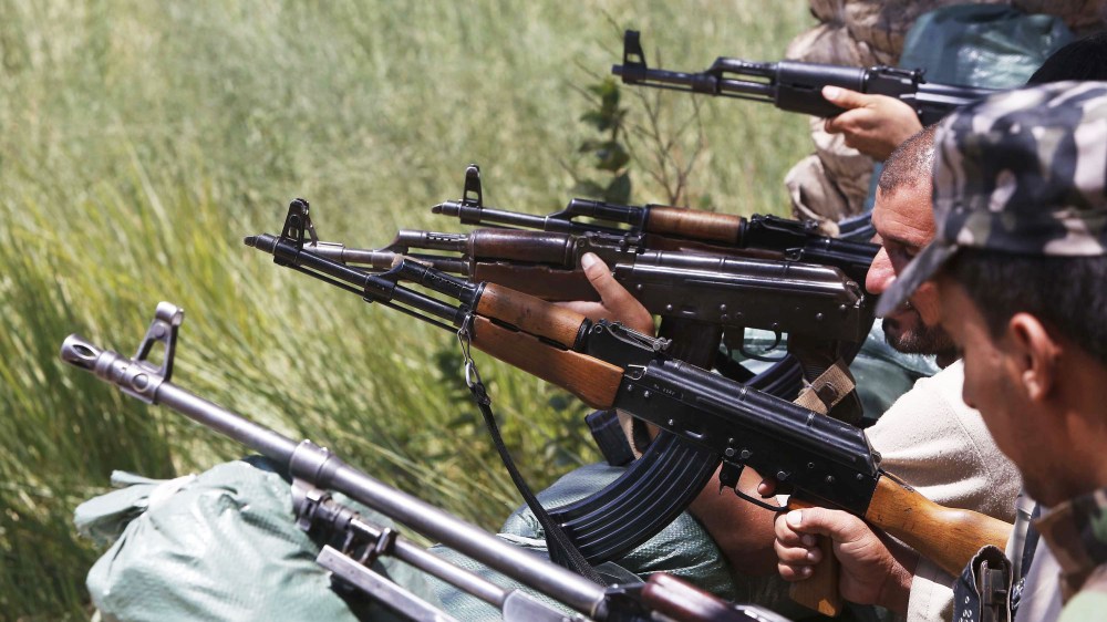 Iraqi soldiers and volunteers from the Abbas Unit fan out into a field in Jurf al Sakhr, 60 kilometers southwest of Baghdad, on August 10, 2014, after they reportedly pushed back Islamic jihadist fighter from the area.