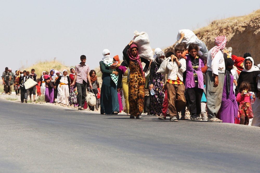 Displaced Iraqi families from the Yazidi community cross the Iraqi-Syrian border at the Fishkhabur crossing, in northern Iraq, on August 13, 2014.
