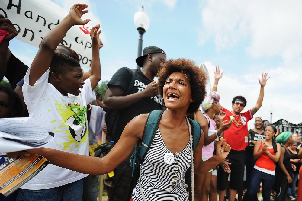 Demonstrators protest outside the Ferguson, Missouri, police department during the National March on Ferguson, August 30, 2014.
