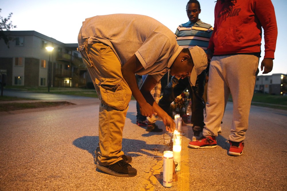 Neighborhood residents light candles at a memorial for 18-year-old Michael Brown on Canfield Street on Oct. 20, 2014 in Ferguson, Mo.