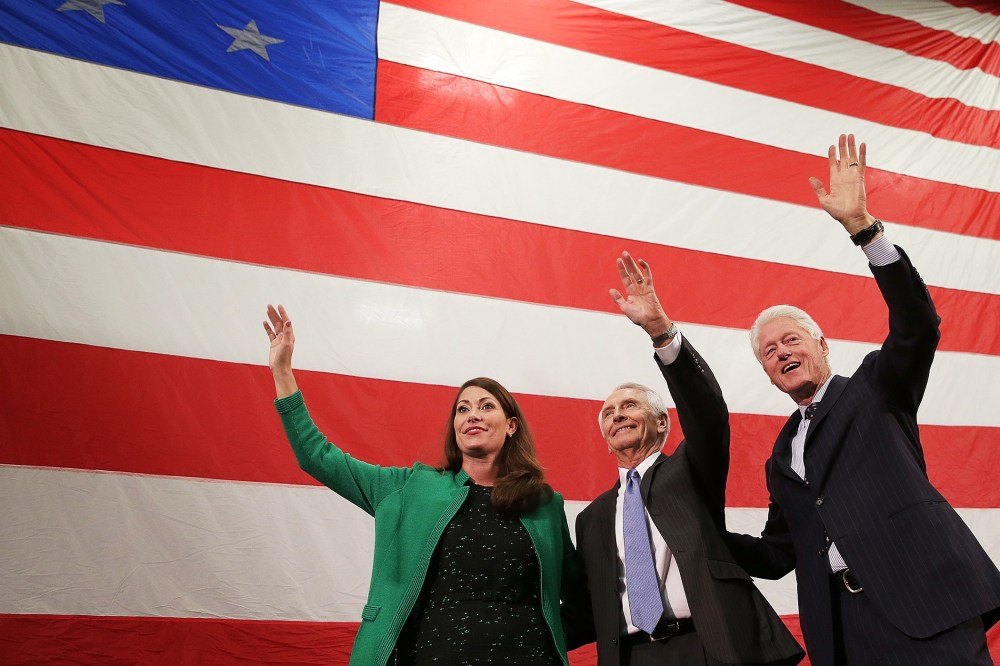 Former U.S. President Bill Clinton (R) campaigns for U.S. Senate Democratic candidate and Kentucky Secretary of State Alison Lundergan Grimes (L) with Kentucky Gov. Steve Beshear (C) during a rally on Oct. 21, 2014 in Paducah, Ky.