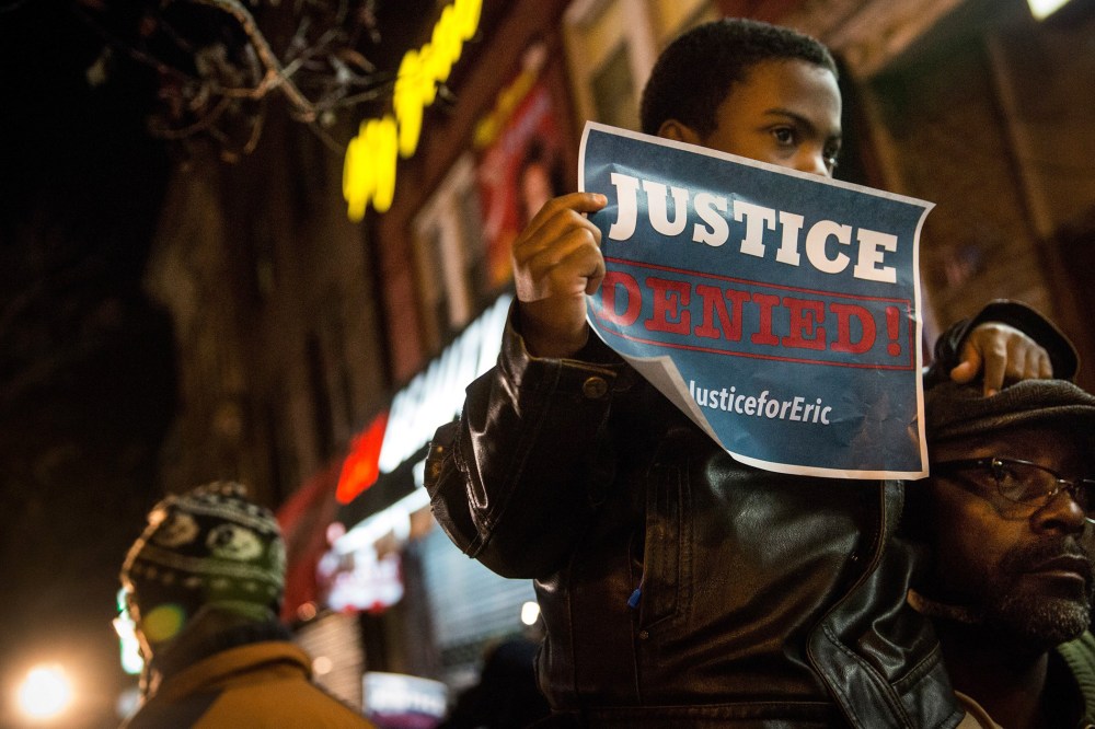 Demonstrators hold an impromptu vigil for Eric Garner, the man killed by a police officer in July using a chokehold, outside the beauty salon where the confrontation took place on Dec. 3, 2014 in the Staten Island borough of New York City.