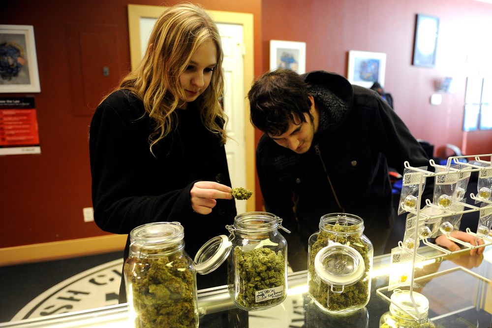 Austin Labry, right, and Kelsey K. from New Orleans, Louisiana check out the selection of wax and shatters at Denver Kush Club, Jan. 1, 2014, in Denver, Colo.