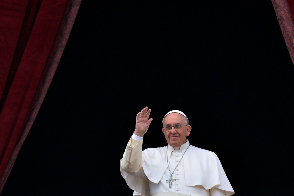 Pope Francis salutes as he gives his traditional Christmas "Urbi et Orbi" blessing from the balcony of St. Peter's Basilica on Dec. 25, 2014 at the Vatican.