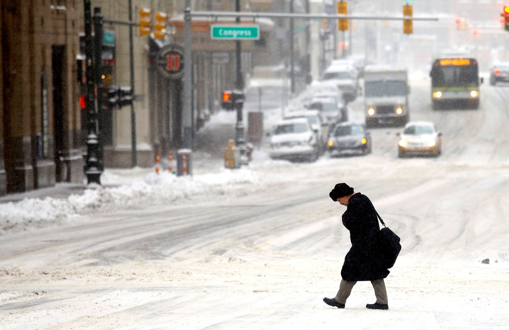 A man navigates through several inches of snow as the area deals with record breaking freezing weather Jan. 6, 2014 in Detroit, Mich.