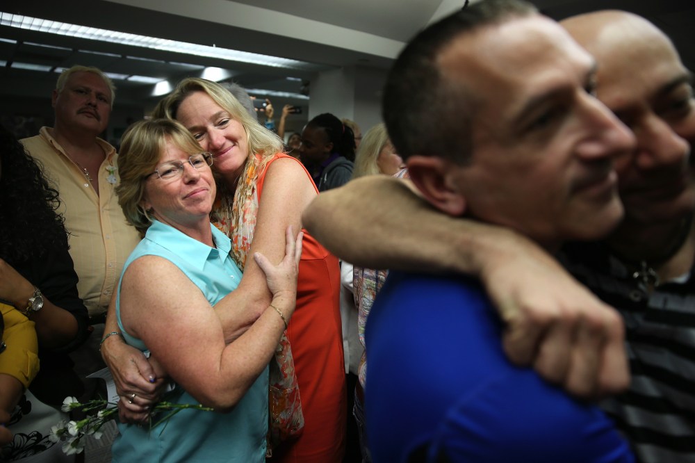 Couples embrace as they attend a wedding ceremony at the Broward County Courthouse on Jan. 6, 2015 in Fort Lauderdale, Fla. (Photo by Joe Raedle/Getty)