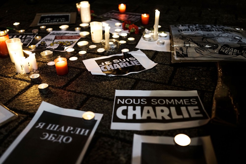Papers with the written words "We are Charlie" lie on the ground while people gather at a vigil in front of the French Embassy following the terrorist attack in Paris on Jan. 7, 2015 in Berlin, Germany. (Photo by Carsten Koall/Getty)