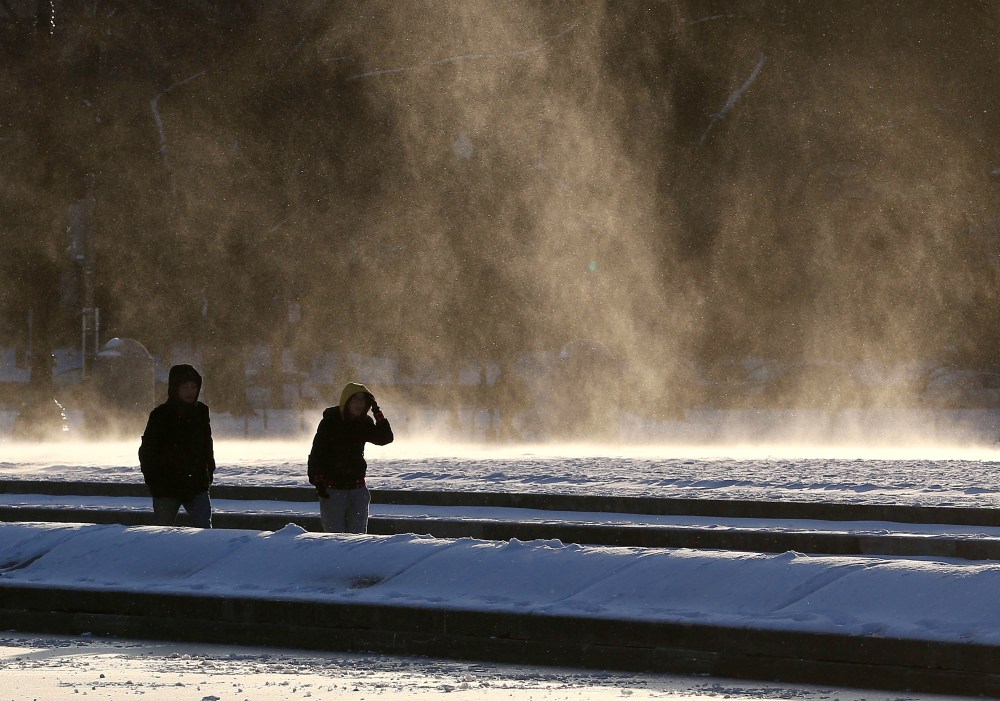 People are windblown as they walk near the frozen reflecting pool in front of the U.S. Capitol on Jan. 7, 2015 in Washington, DC. The Washington area is experiencing heavy winds with temperatures in the teens. (Mark Wilson/Getty Images)