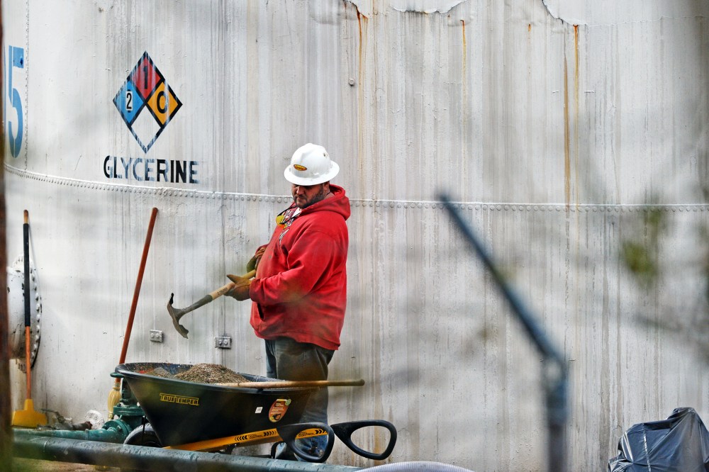 An unidentified worker at Freedom Industries shovels NAPA premium oil absorbent in Charleston, West Virginia, Jan. 10, 2014.