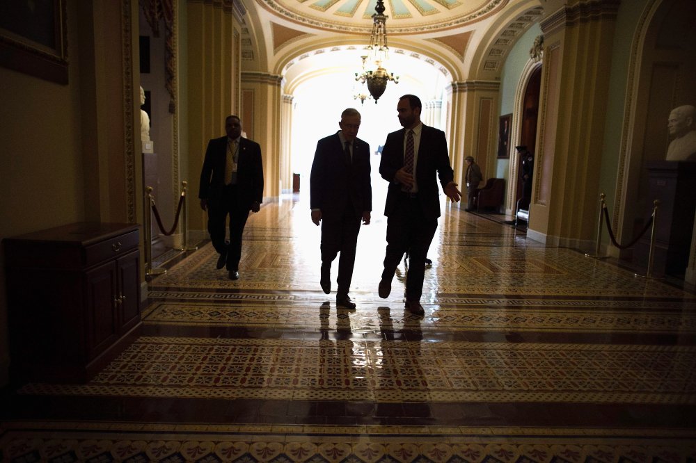 Senate Majority Leader Harry Reid (D-NV) (2nd L) talks with Senior Intelligence and Defense Advisor Tommy Ross (R) while walking through the U.S. Capitol after opening the Senate for the week, January 13, 2014 in Washington, D.C.