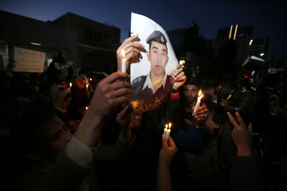 Jordanian youth hold a picture of pilot Muath Al Kasasbeh, who was a hostage of the Islamic State, as they gather for a vigil to condemn the killing of two Japanese hostages in Amman, Jordan, on Feb. 2, 2015. (Photo by Jordan Pix/Getty)