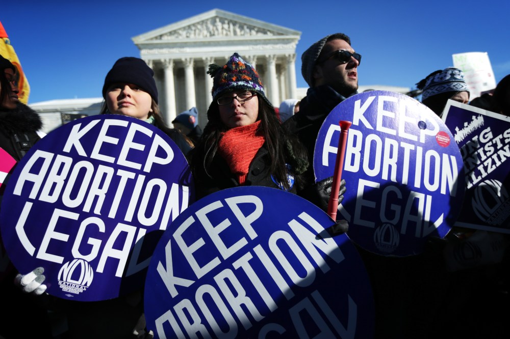 Pro-choice activists hold signs as marchers of the annual March for Life arrive in front of the U.S. Supreme Court on Jan.22, 2014 on Capitol Hill in Washington, DC