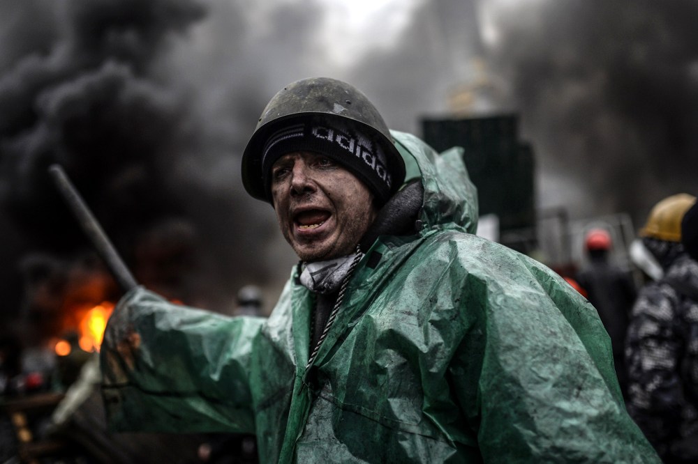 A protester stands behind barricades during clashes with police on February 20, 2014 in Kiev.